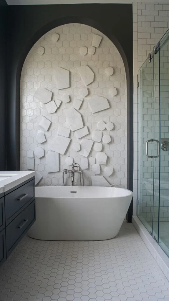 Contemporary luxury accent wall within a dark arched niche, featuring white hexagonal tile background overlaid with various floating, raised white 3D geometric shapes/slabs above a white tub.