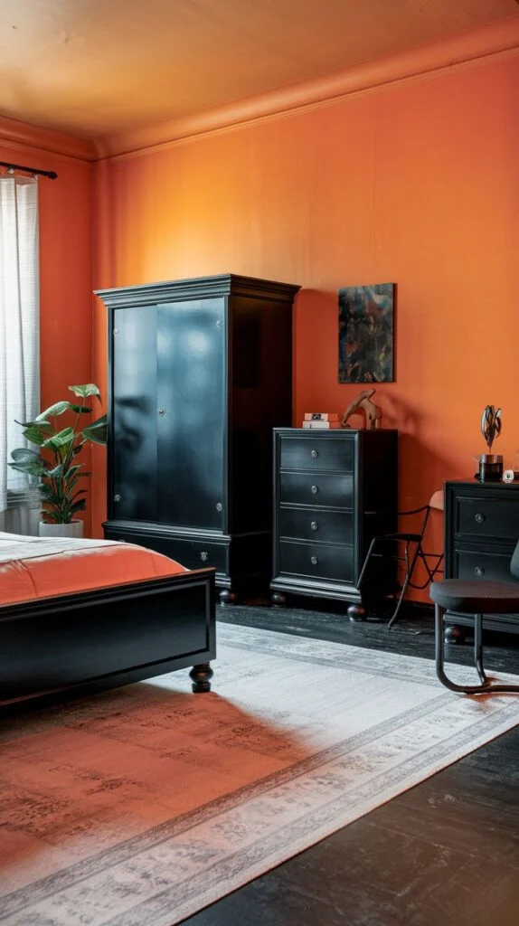 Black bedroom furniture contrasted with bright orange walls
