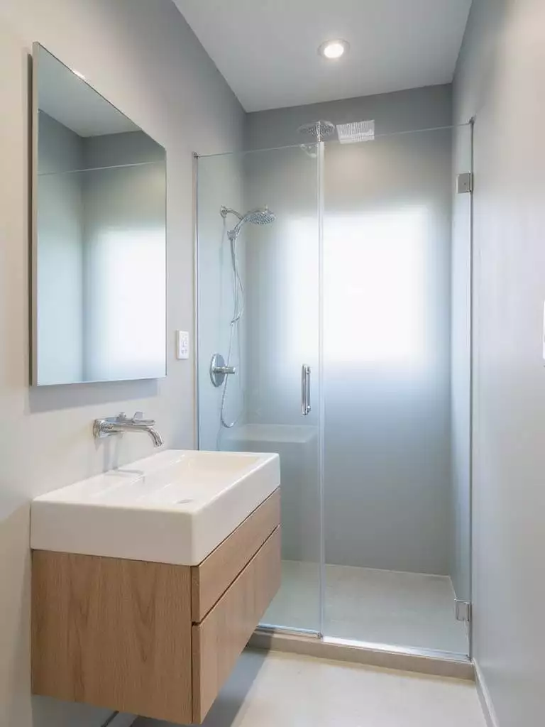 Small modern bathroom with floating vanity and glass shower enclosure