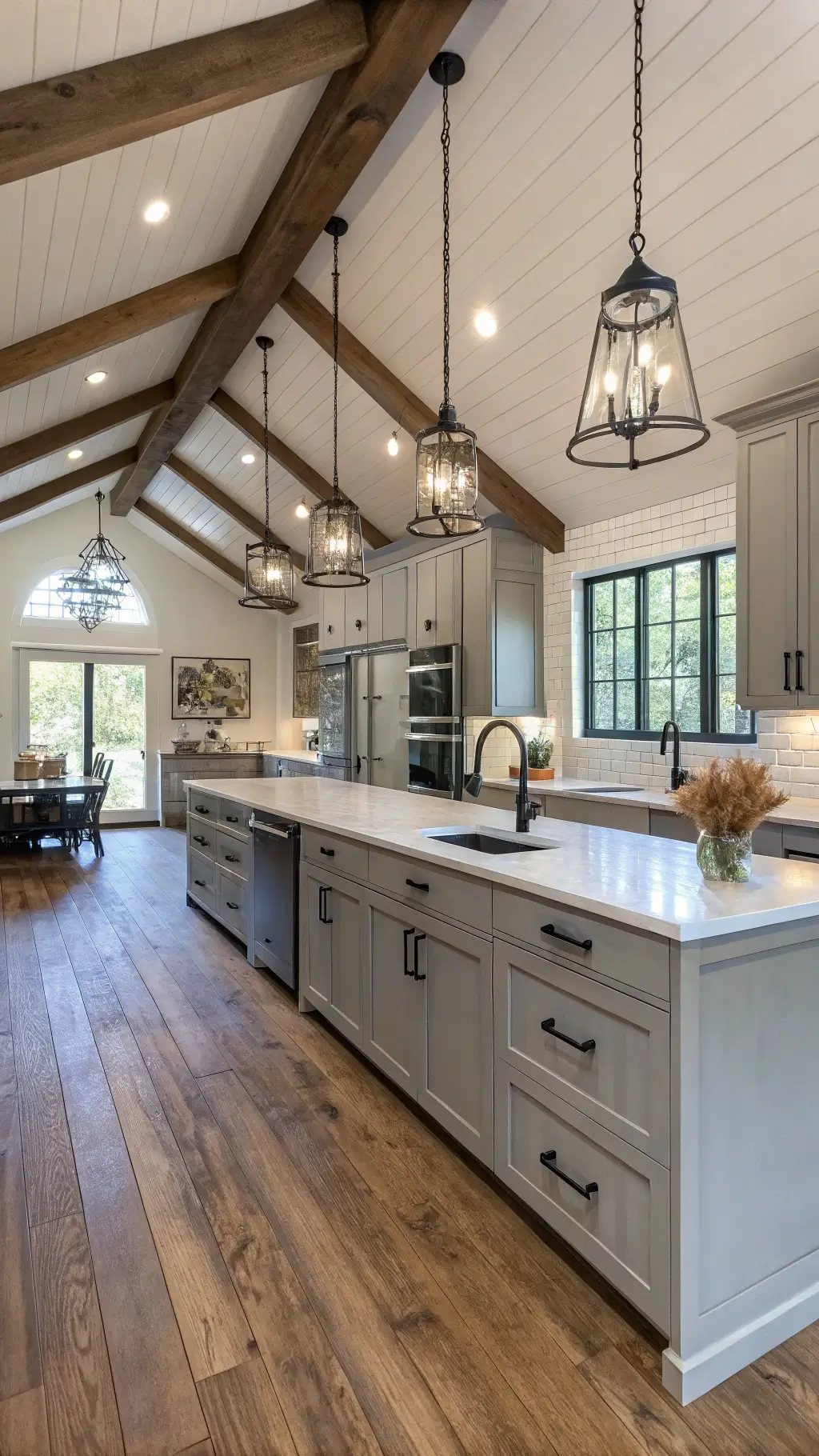 Modern farmhouse kitchen with vaulted ceiling, dove gray cabinets, wide-plank oak floors, and contemporary pendant lights, capturing a balance of rustic and refined aesthetics