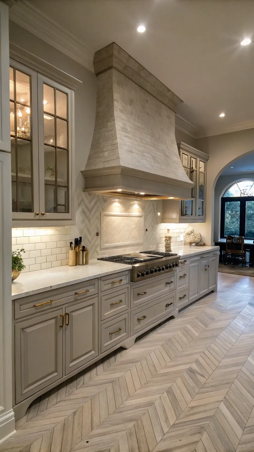 Open-concept kitchen with herringbone flooring and limestone hood