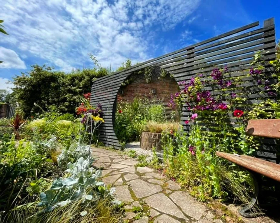 Modern horizontal slat privacy screen with flowering vines